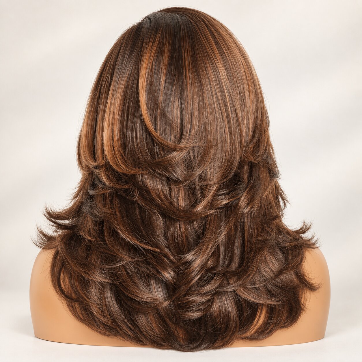 Back view of a brown highlight butterfly cut wig showing graduated layers and curved ends.