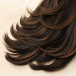 Back view of a brown highlight human hair wig with feathered butterfly layers and soft flipped ends.