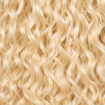 Black woman wearing #613 blonde Burmese curly crochet hair styled in soft boho braids