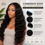 Black woman wearing UrbanChichair Cambodian Wave tape in hair extensions with long glossy waves, natural blend, and full volume