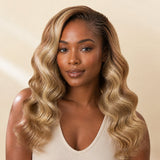Black woman wearing a full #27/#613 blonde blend body wave crochet human hair protective style, front view