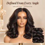 Black woman wearing a shoulder-length Natural Black body wave human hair wig with full face-framing curls and soft, glossy volume.
