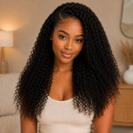Black woman wearing full Virgin Kinky Curly Bundles in natural black color, featuring defined curls, soft shine, and a natural voluminous look.