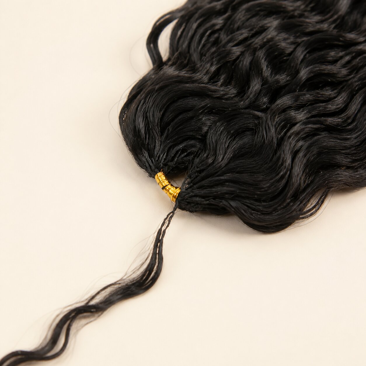 Close-up of Natural Wave Human Crochet Hair bundle root with a gold spiral wrap and fine strand tail.