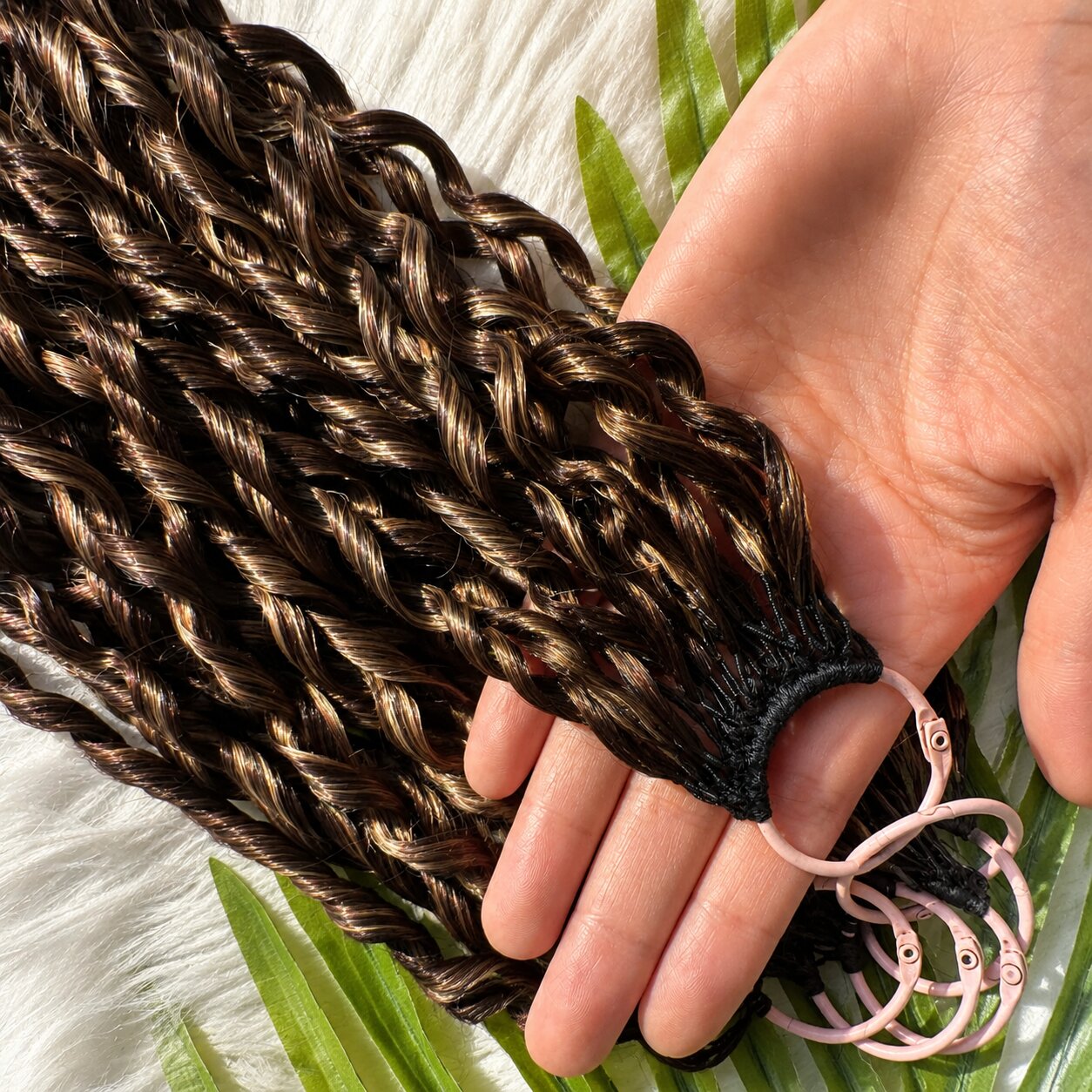 Close-up of hand holding Feathered Crochet Hair bundle, showing soft feathered curls, natural texture, glossy 100% human hair, pre-looped strands, detailed view of hair quality