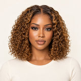 Front view of a model wearing an UrbanChichair caramel brown highlight deep curly glueless wig with a middle part.