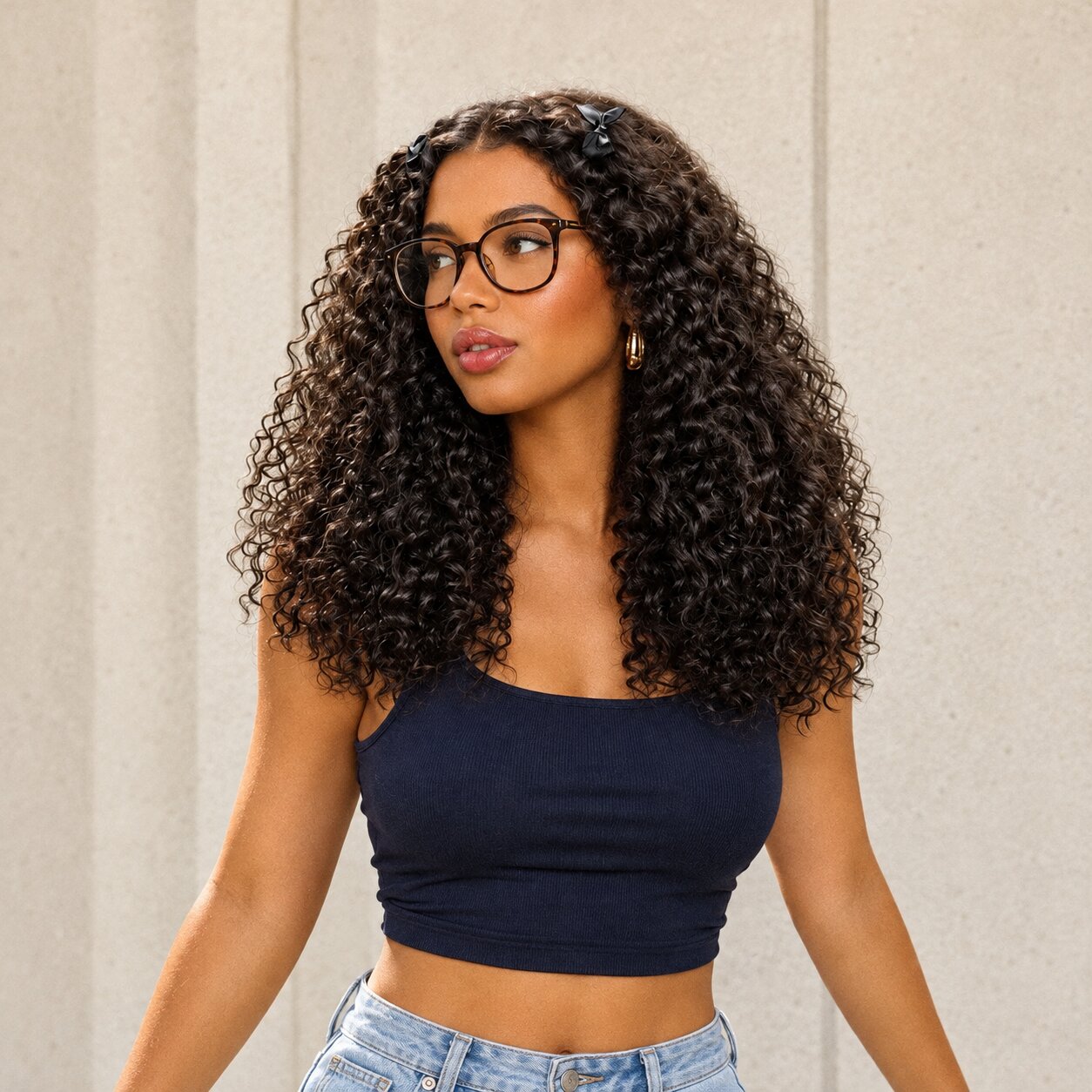 Kinky curly wig styled with the bangs pinned back, worn with glasses and a navy top.