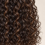 Overhead view of the curved part and water wave texture on a brown highlight wig.