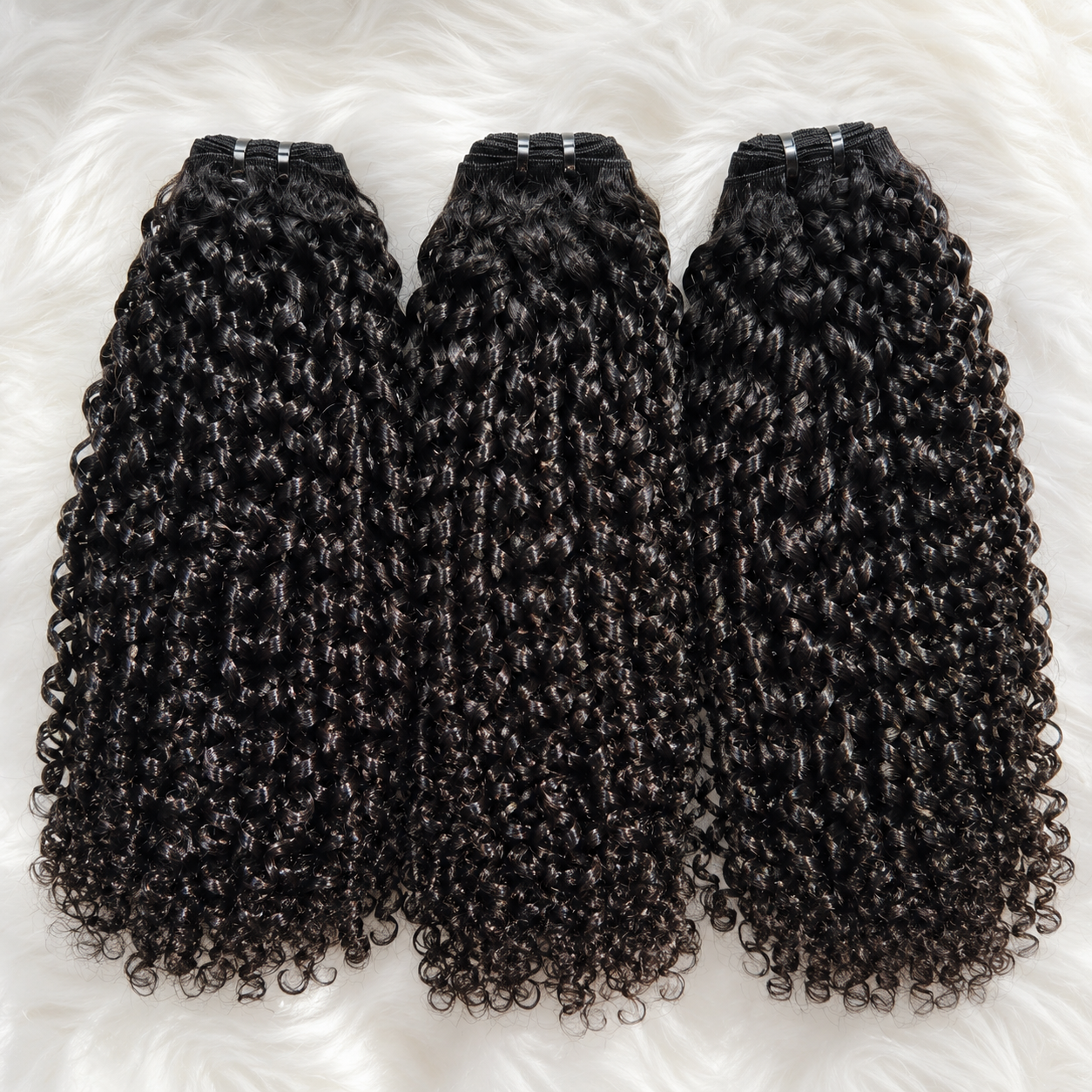 Raw Pixie Curly Bundles Double Drawn flat lay featuring three black curly human hair bundles on a soft white fur background by UrbanChichair