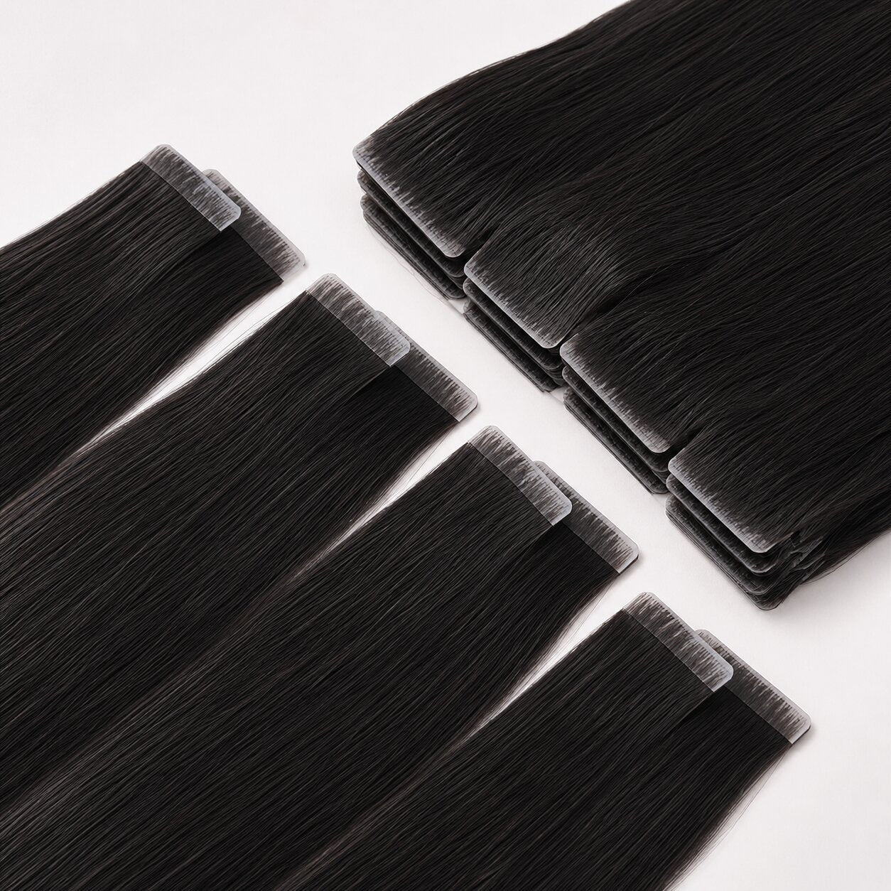 Straight Invisible Tape In Hair Extensions laid flat, showing smooth black human hair with seamless invisible tape tabs.