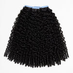 UrbanChichair Eurasian Curly Tape In Hair Extensions in natural black human hair with full double drawn curls on a clean white background.