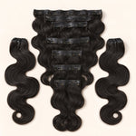 UrbanChichair Soft Body Wave Seamless Clip-in Human Hair Extensions in natural black, flat lay showing glossy body wave texture and secure clip-in wefts.